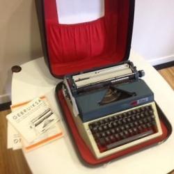 Typemachine vintage, merk Erika met koffer, boekjes en lint.